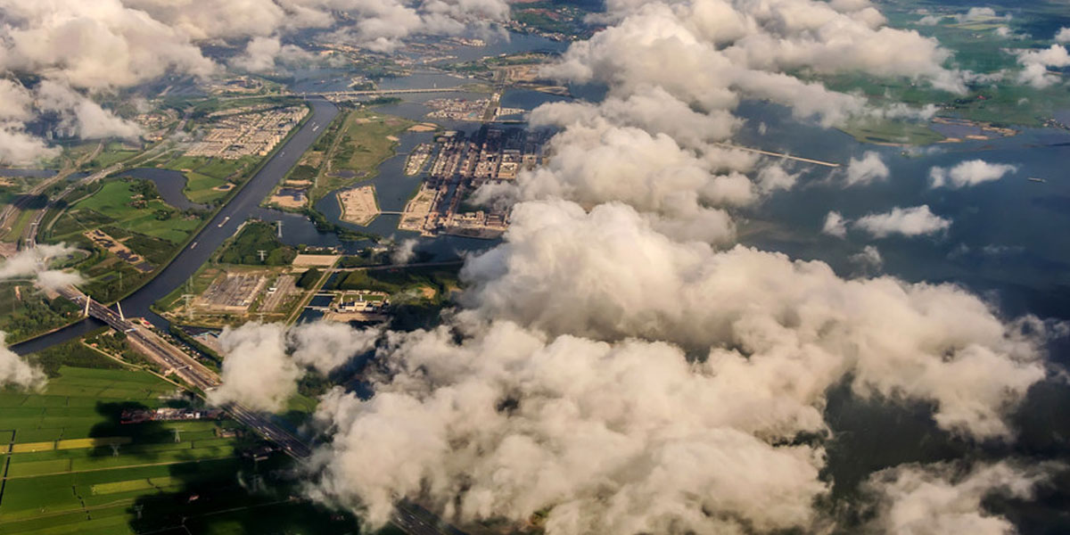 Вид на Землю из иллюминатора самолёта сквозь облака
